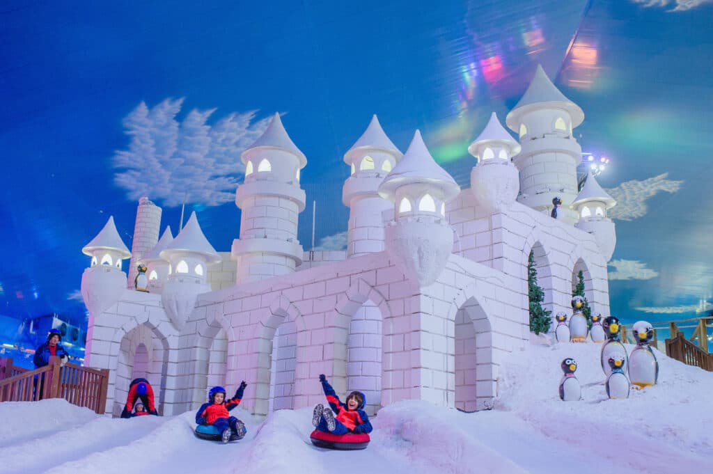 Snowland em gramado, com crianças se divertindo na neve