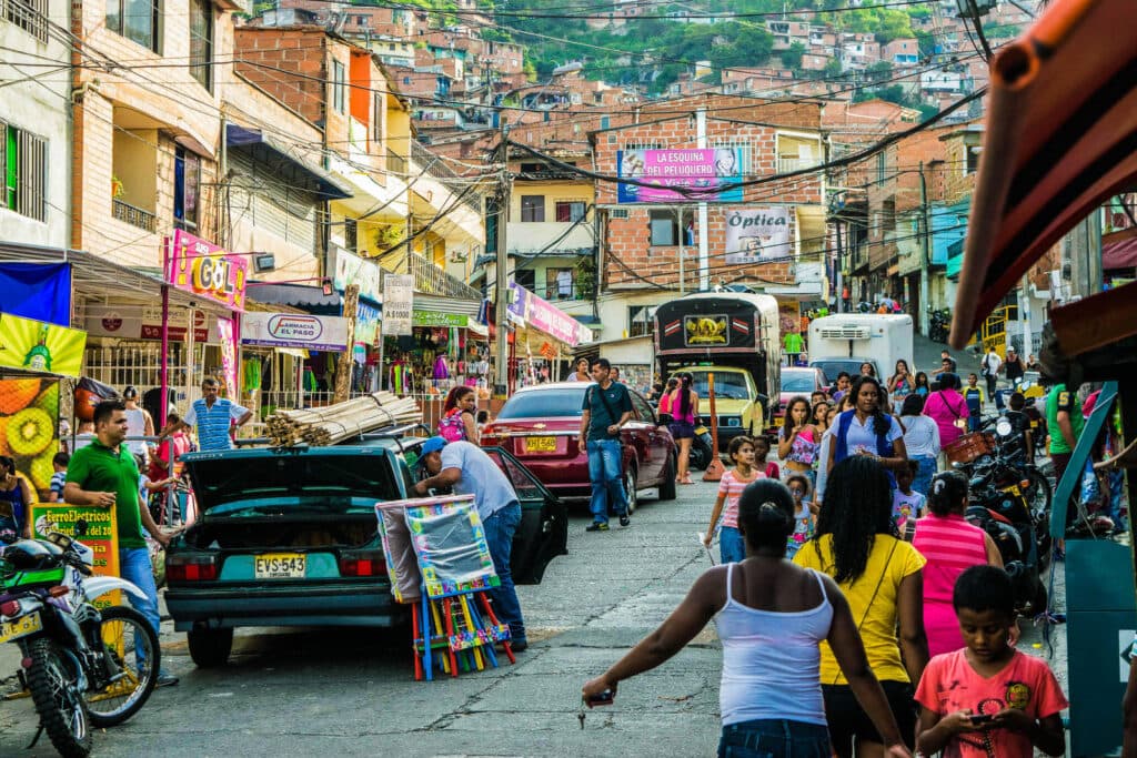 Comuna 13 em Medellin e diversas pessoas andando pelas ruas