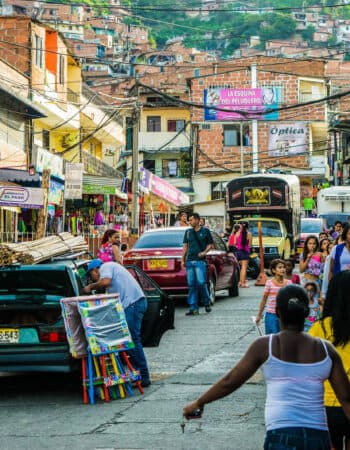 Comuna 13 em Medellin e diversas pessoas andando pelas ruas