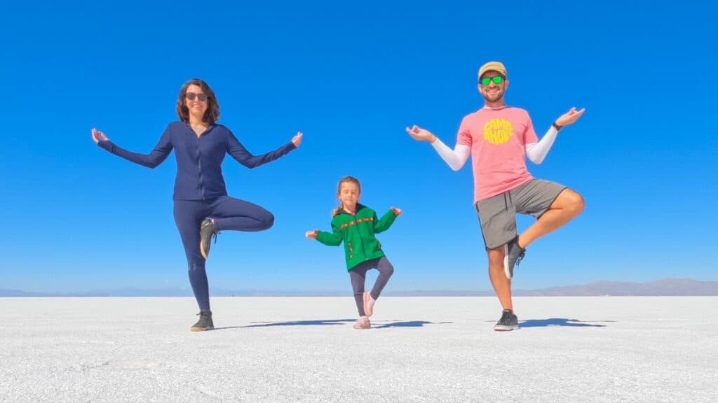 Família posando em poses divertidas com céu azul