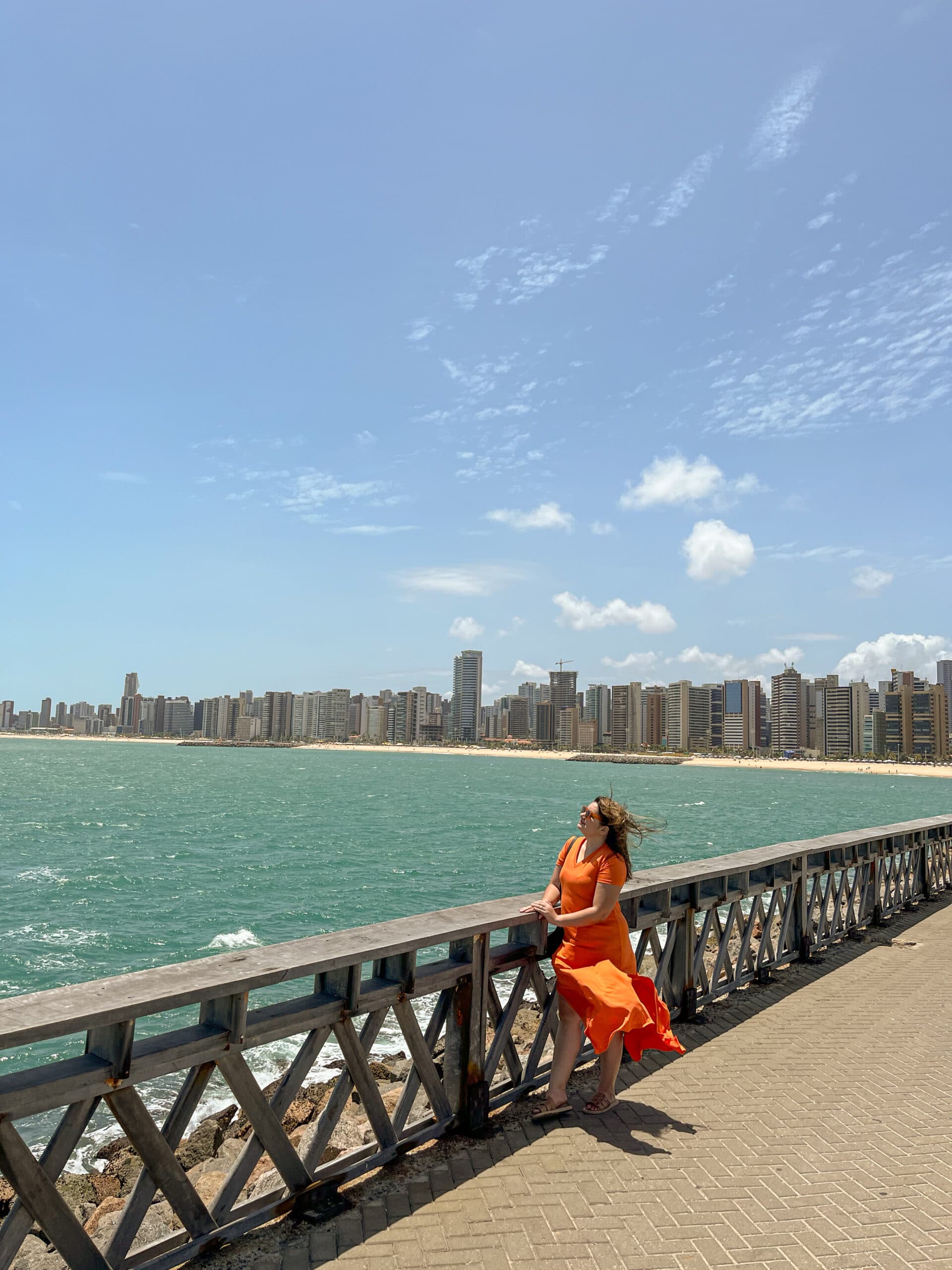 Mulher sob uma ponte e mar ao fundo