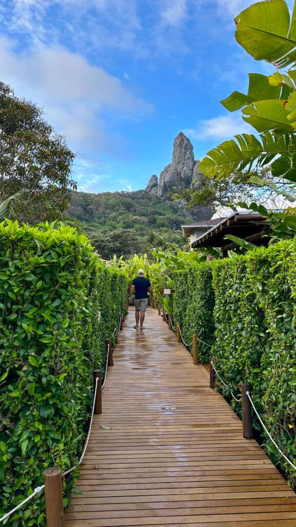 Hoemem caminhando por uma paçarela de madeira em um parque em Fernando de Noronha, em Pernambuco