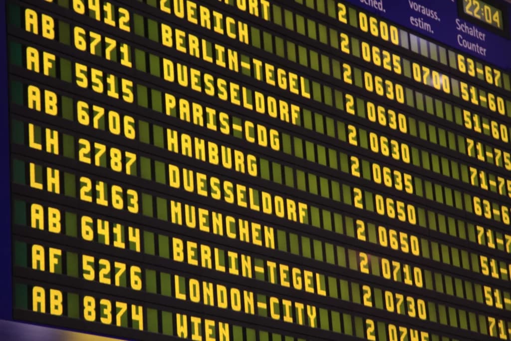 Painel de aeroporto mostrando os voos e portões de embarque com o fundo preto e letras amarelas iluminadas