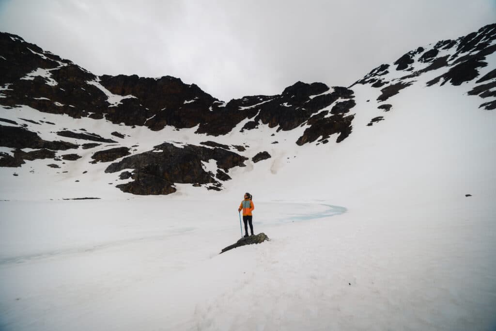 Montanhas cobertas de gelo e mulher no meio da paisagem admirando tudo