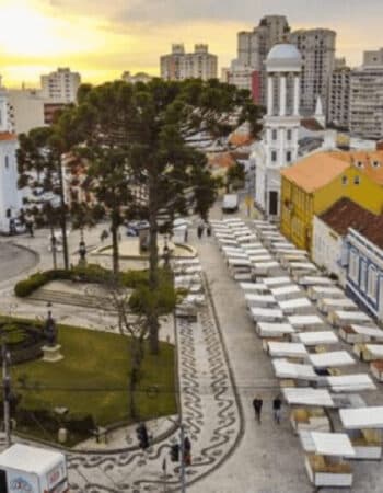 Feira artesanal em curitiba, com várias barracas na rua e muitas pessoas